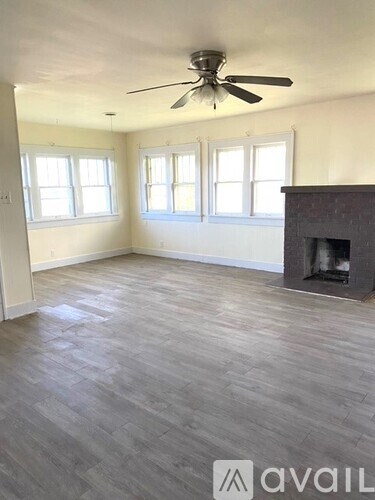 A room with a fireplace and a ceiling fan.