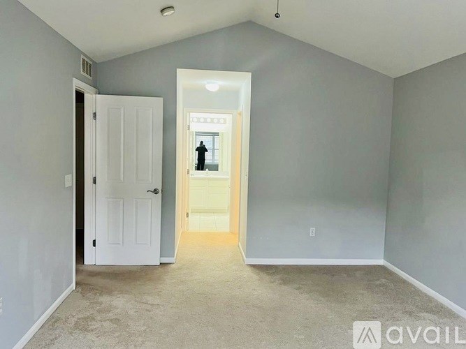 A room with a white door and a mirror on the wall.