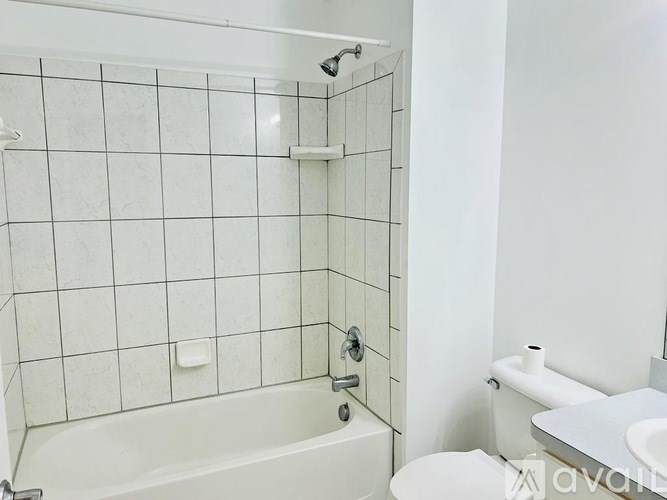 A white bathroom with a tub, toilet and sink.