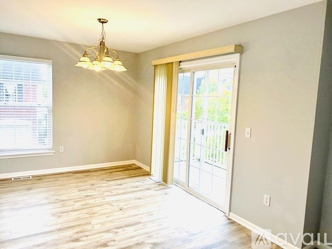 A room with a wooden floor and a chandelier hanging from the ceiling.