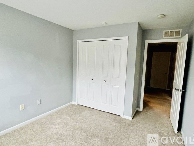 A room with a white door and carpeted floor.