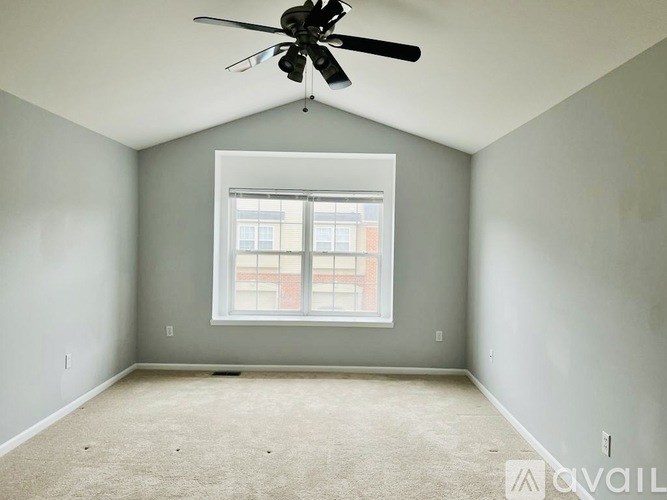 A room with a ceiling fan and a window.
