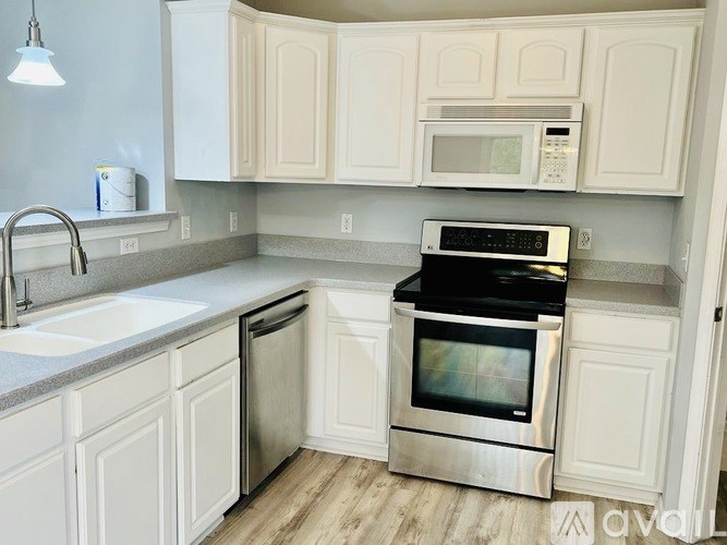 A kitchen with white cabinets and a stainless steel oven.