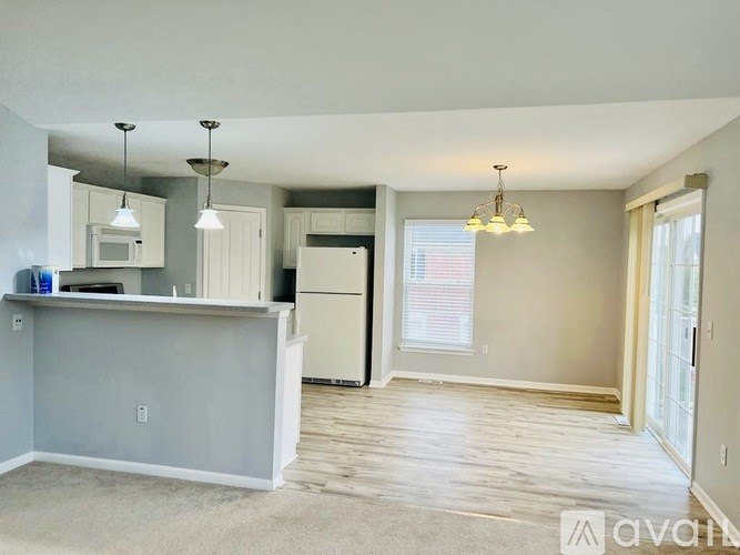 A kitchen with a refrigerator, microwave, and cabinets.