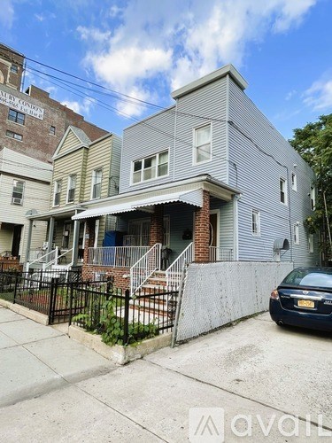 A grey house with a car parked in front.