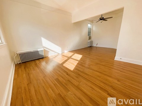 A room with wooden flooring and a ceiling fan.