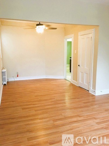 A room with wooden floors and a ceiling fan.