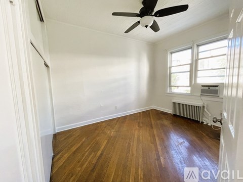 A room with wooden floors and a ceiling fan.