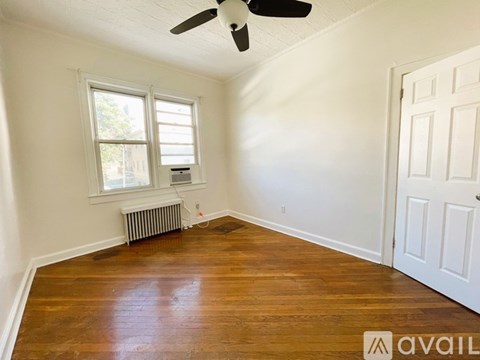 A room with a ceiling fan, a window, and a door.