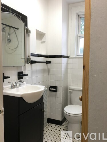 A bathroom with a sink, toilet and a mirror.