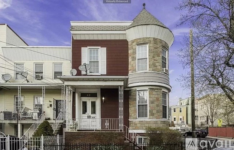 A house with a brown and white facade has a white door and a small balcony.
