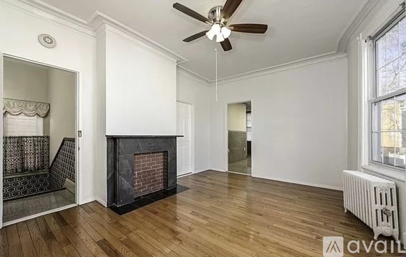 A room with a fireplace and a ceiling fan.