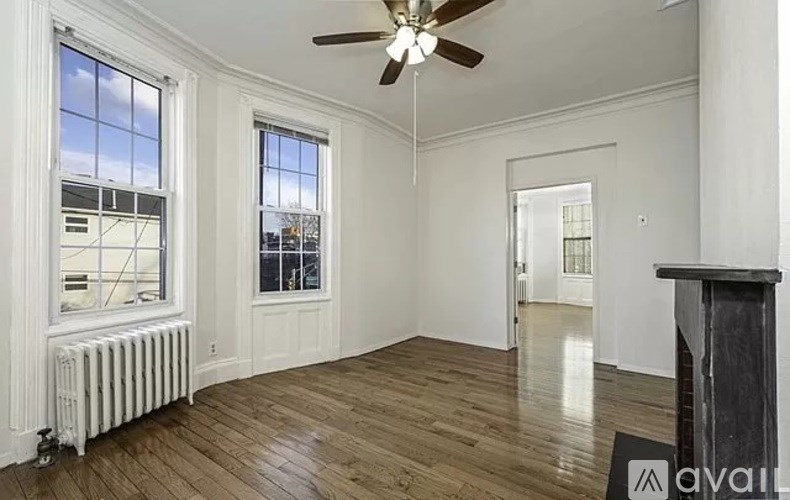 A room with wooden floors and a ceiling fan.