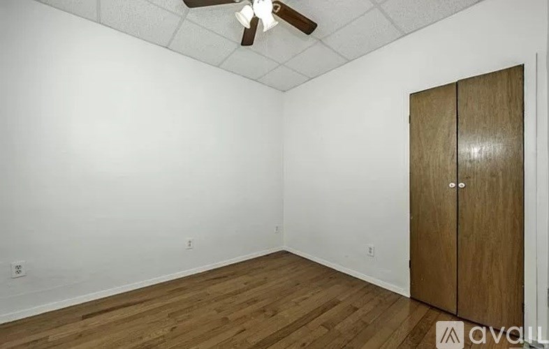 A room with a wooden floor and a ceiling fan.