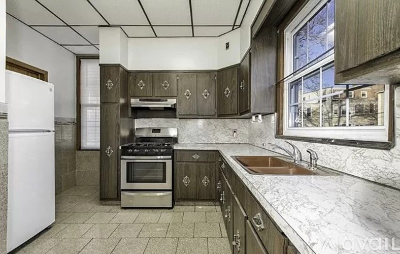 A kitchen with a white fridge, a stove, and a sink.