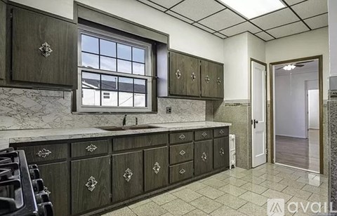 A kitchen with dark wood cabinets and a marble countertop.