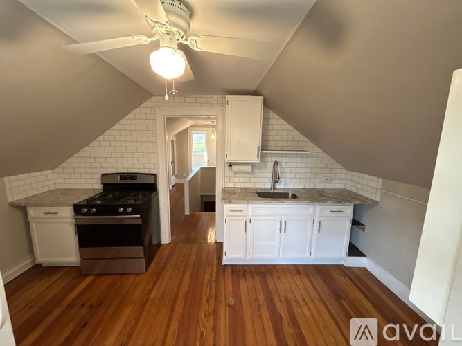A kitchen with white cabinets and a wooden floor.