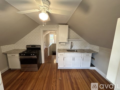 A kitchen with white cabinets and a wooden floor.