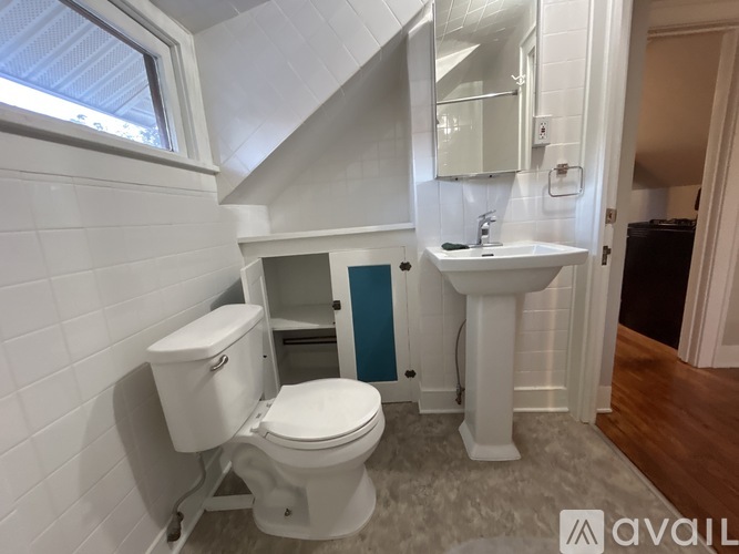 A white toilet and sink in a small bathroom.