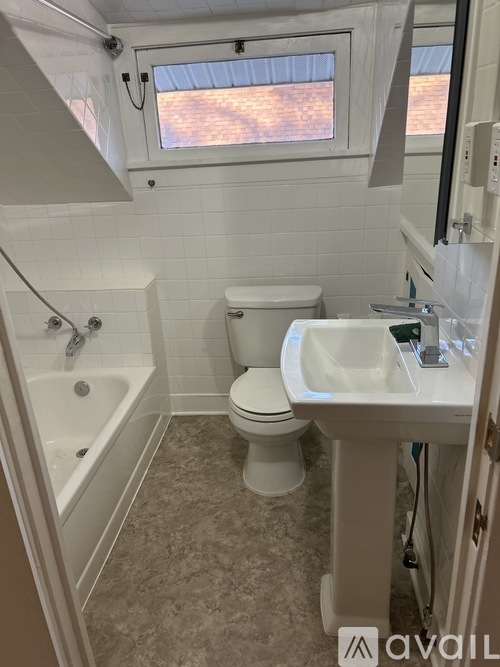 A bathroom with a toilet, sink, and bathtub.