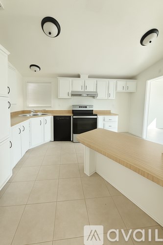 A kitchen with white cabinets and a black stove top oven.