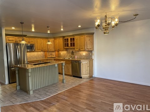 A kitchen with wooden cabinets and a refrigerator.