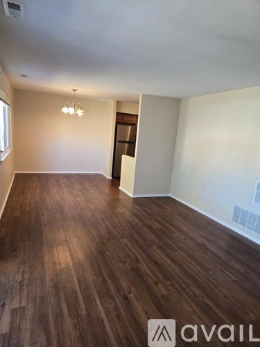 A room with wooden flooring and a white wall.