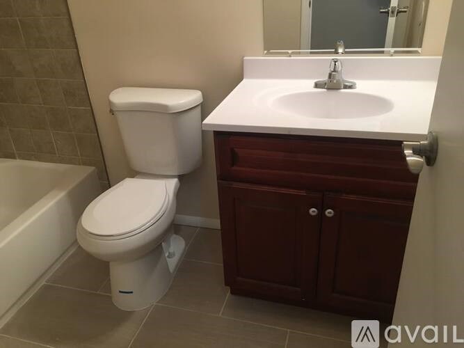 A white toilet sits next to a white sink in a bathroom.