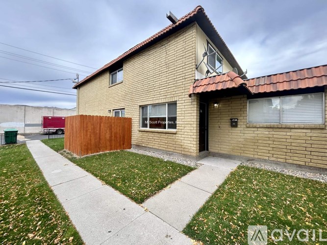 A house with a brown fence and a red trailer in the background.