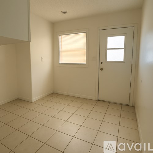 A room with a door, a window with blinds, and a wall with a small hole.