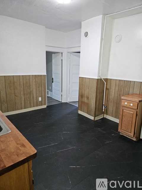 A room with a wooden cabinet and a black floor.