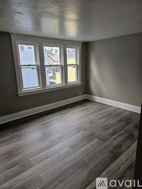 A room with a window and wooden flooring.