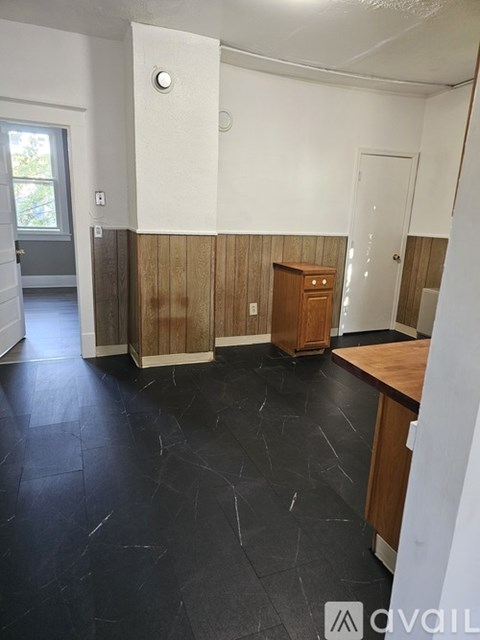 A room with a wooden cabinet and a black floor.