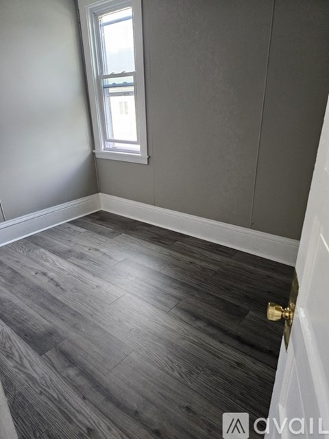 A room with a wooden floor and a window.