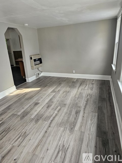A room with wooden flooring and a wall-mounted monitor.