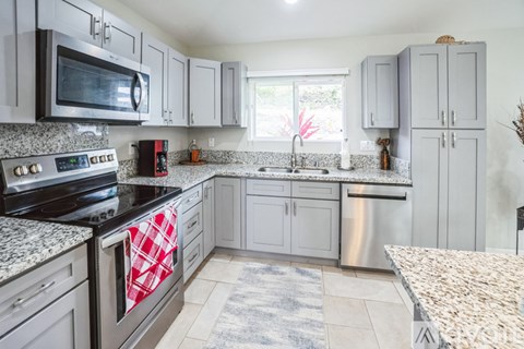 A kitchen with a stove top oven and microwave.