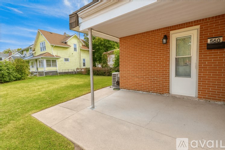 A house numbered 560 with a white door and a brick wall.
