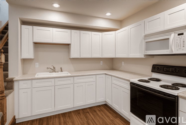 A kitchen with white cabinets and a black stove top oven.