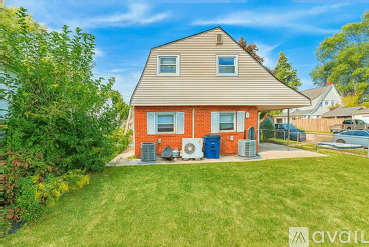A house with a red and beige exterior is surrounded by greenery and has two air conditioning units outside.