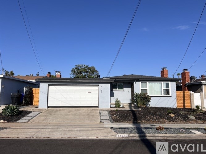 A house with a garage and a driveway in front of it.