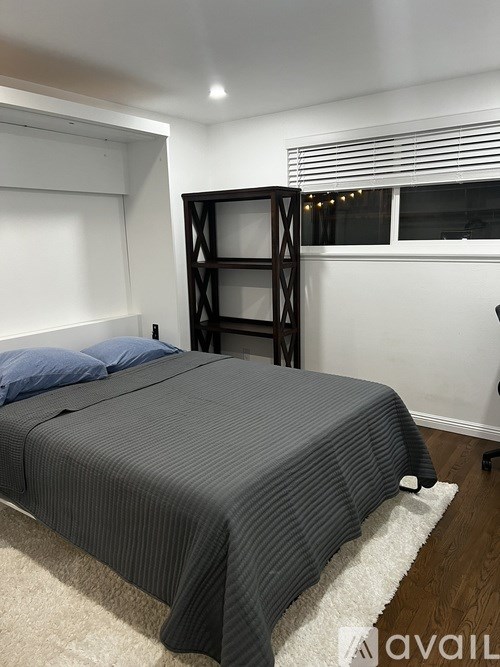 A bedroom with a bed and a shelf.