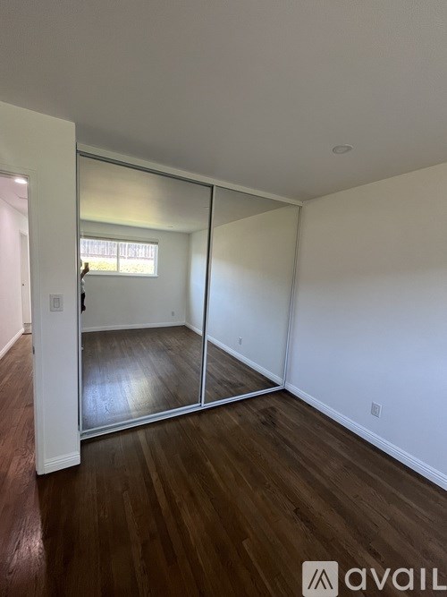 A room with a sliding door and wooden flooring.
