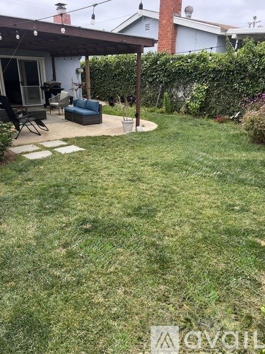A backyard with a lawn and a patio area.