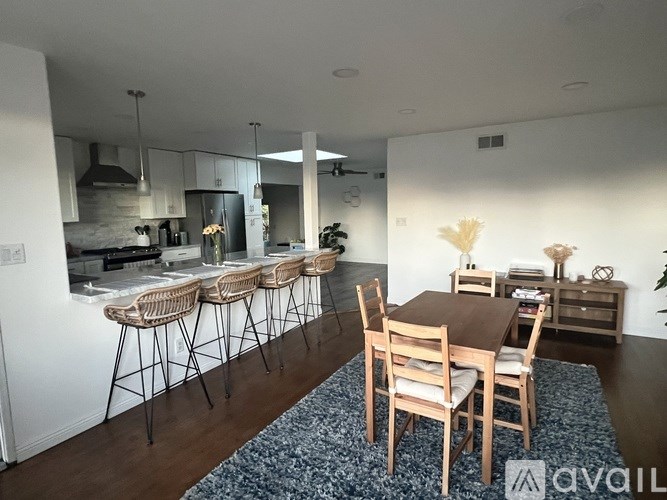 A modern kitchen with a dining table and chairs.