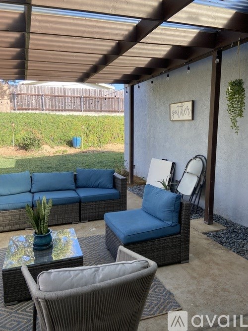 A patio with a sofa, chair, and table.