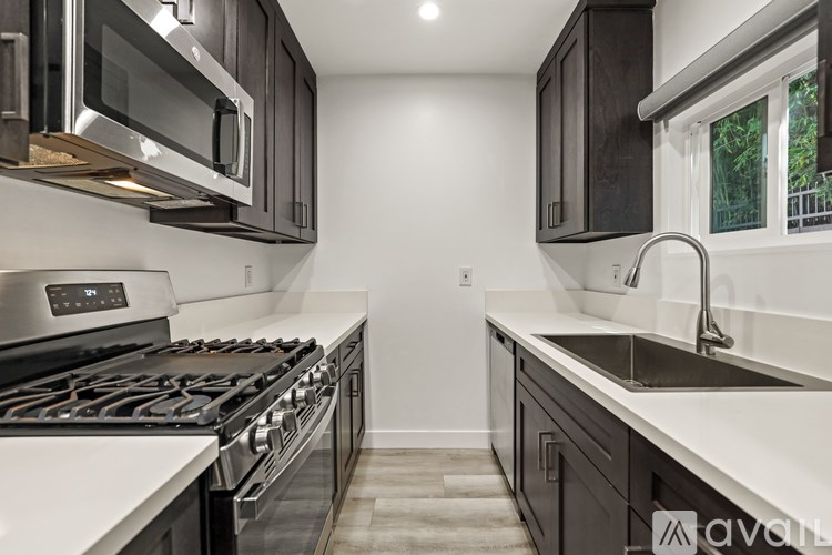 A modern kitchen with a stove top oven and a microwave above it.