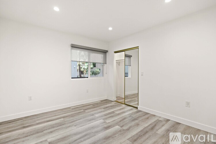 A room with a wooden floor and a mirror on the wall.