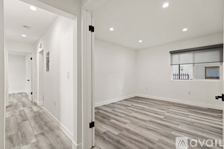 A room with a wooden floor and white walls is available for rent.