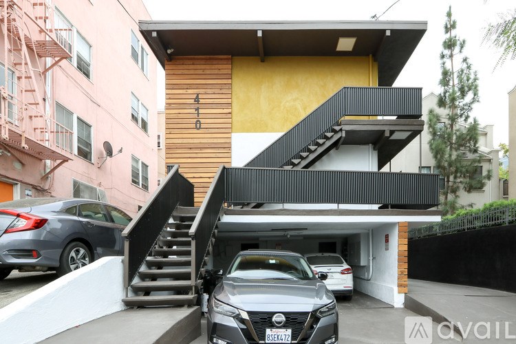 A black car is parked in a garage in front of a house.