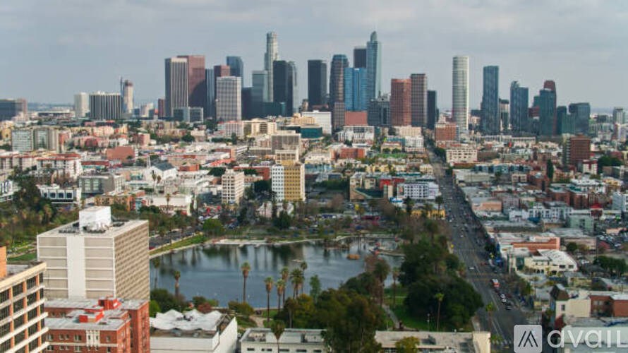 A cityscape with a body of water in the foreground and tall buildings in the background.